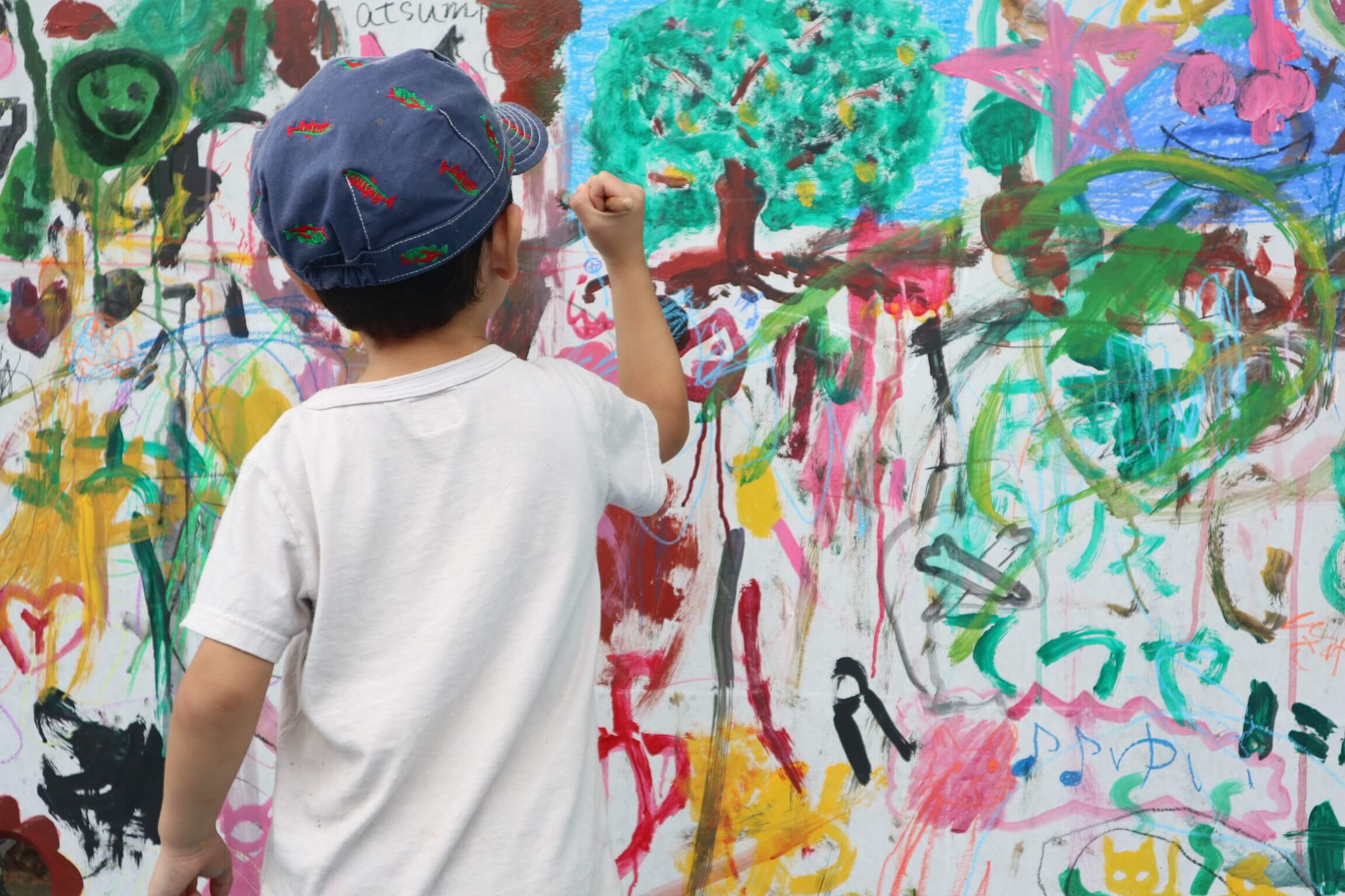 絵の具で壁に落書きする子供
